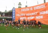 The GWS Giants run through a banner calling out domestic violence. Picture Getty Images