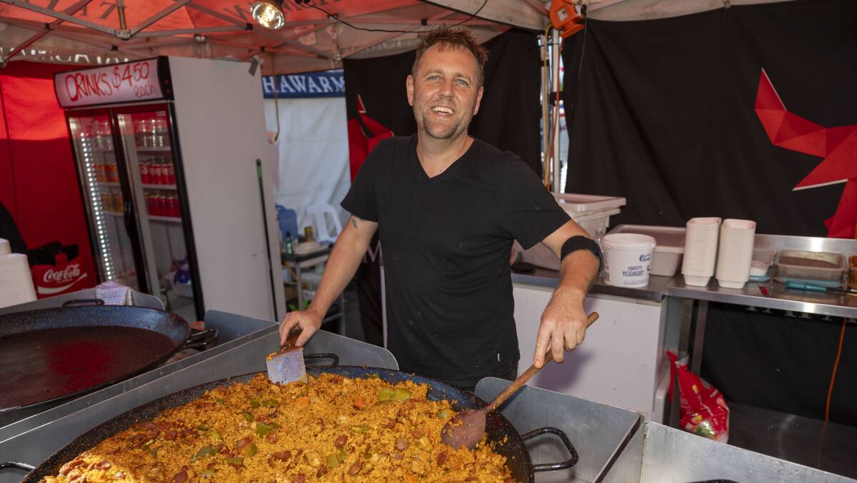 Stallholder Jai Hoinville serving paella at the folk festival.