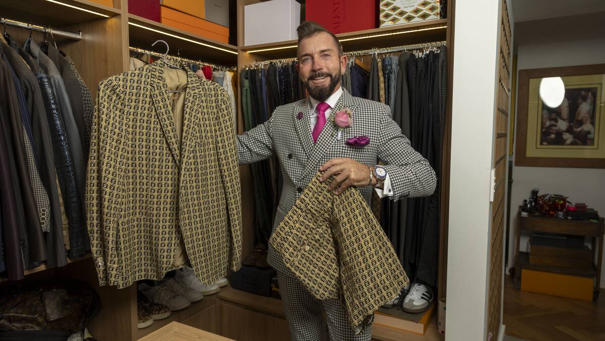 Mr Luton holding the shorts-and-jacket set he wore to last year's Melbourne Cup. Picture by Gary Ramage