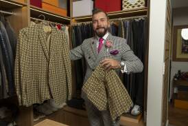 Mr Luton holding the shorts-and-jacket set he wore to last year's Melbourne Cup. Picture by Gary Ramage