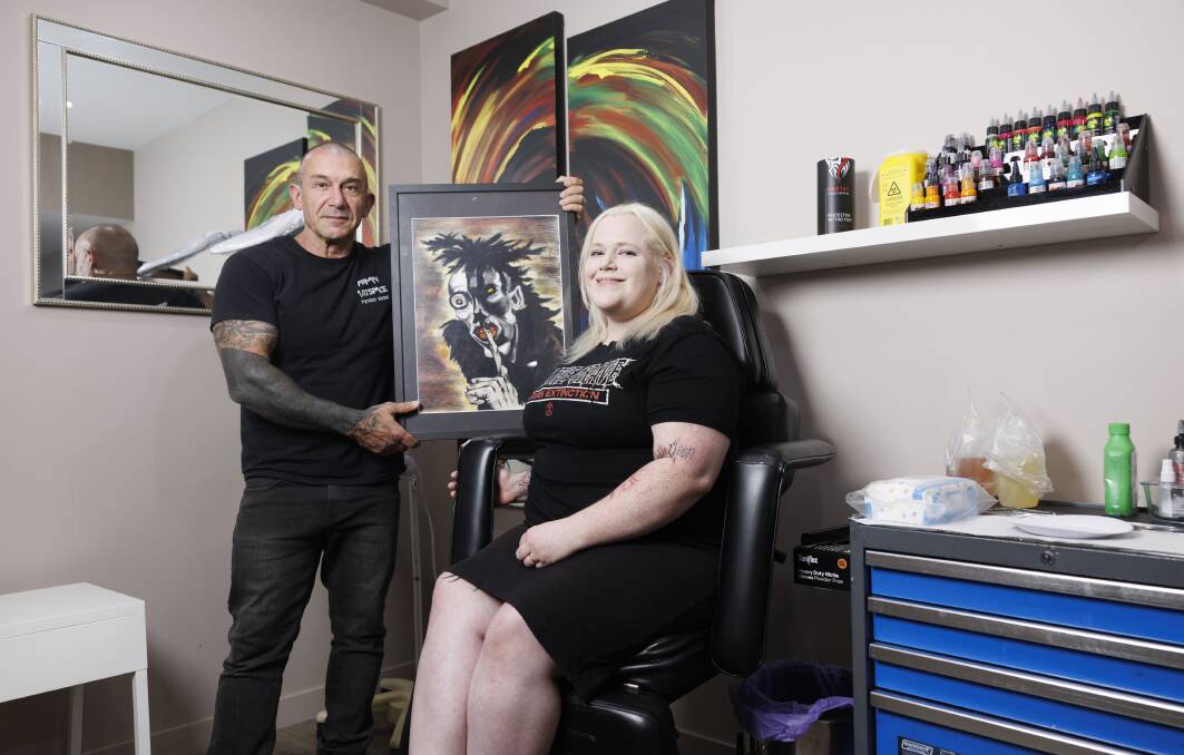 George Theodosiou, owner of Armani Art, and Josie McGrath, who bought this painting nearly 20 years ago. Picture by Keegan Carroll
