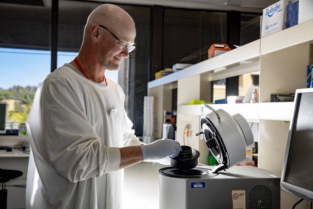 Molecular scientist Darren Taylor loads a carousel of samples taken for COVID-19 testing into a real-time PCR instrument at Canberra Hospital's molecular microbiology department. Picture: Sitthixay Ditthavong