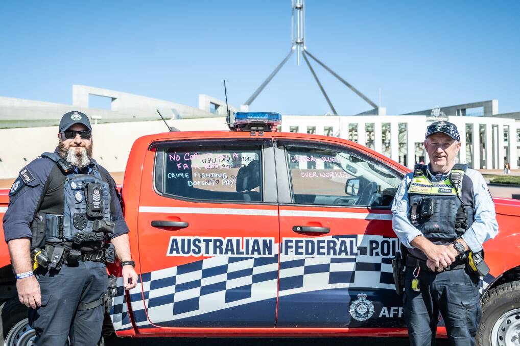 Sergeant Simon Marriott and Senior Constable Andrew Nisbet with the industrial slogans on their police vehicle outside Parliament House. Picture by Karleen Minney