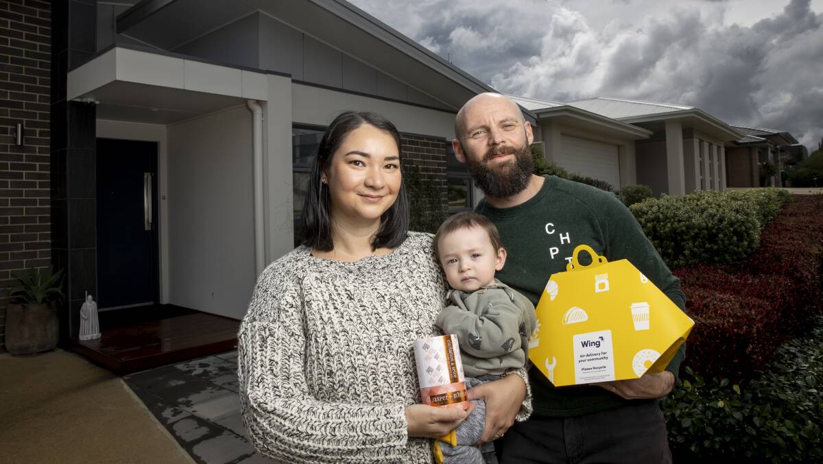 Pauline and Greg Parish with Ryder in front of their Crace home, where they have been trialing drone deliveries by Wing. Picture: Sitthixay Ditthavong