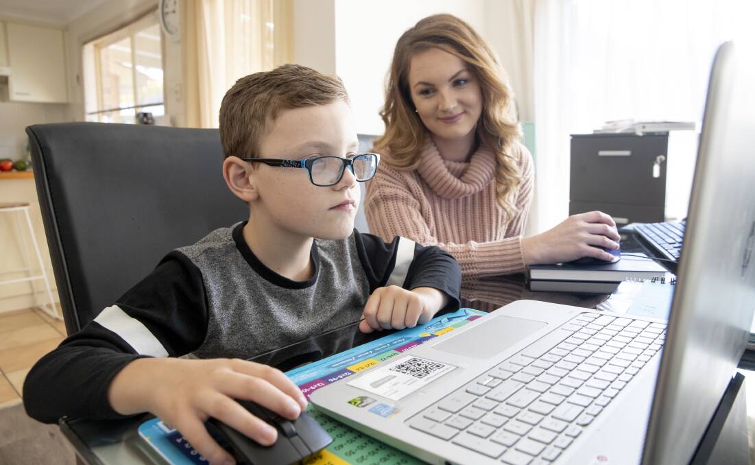 Iydin Pasa, 8, tackles Mathletics with his mother Lauren Ross working from home by his side. Picture: Sitthixay Ditthavong 