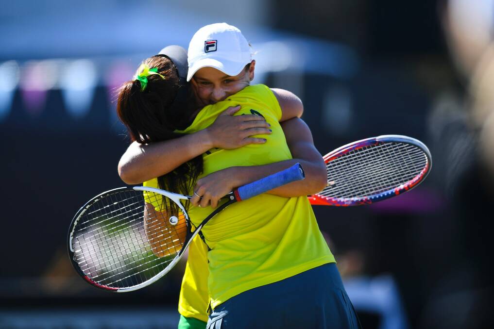 Casey Dellacqua and Ash Barty celebrate their decisive doubles win. Photo: AAP
