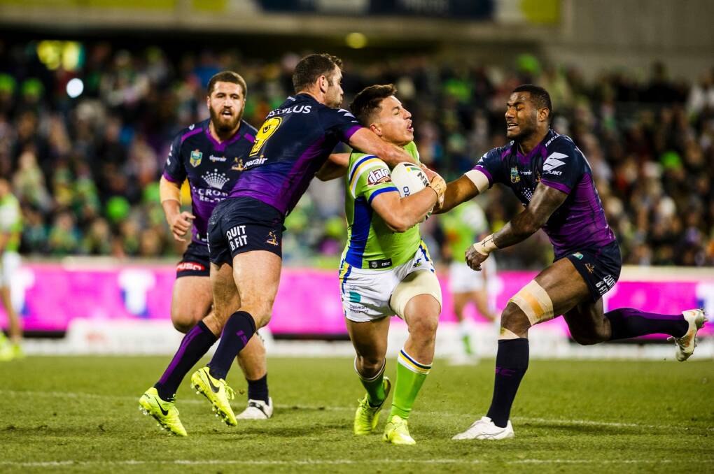 Joseph Tapine is tackled by Cameron Smith (left) and Suliasi Vunivalu. Photo: Jamila Toderas