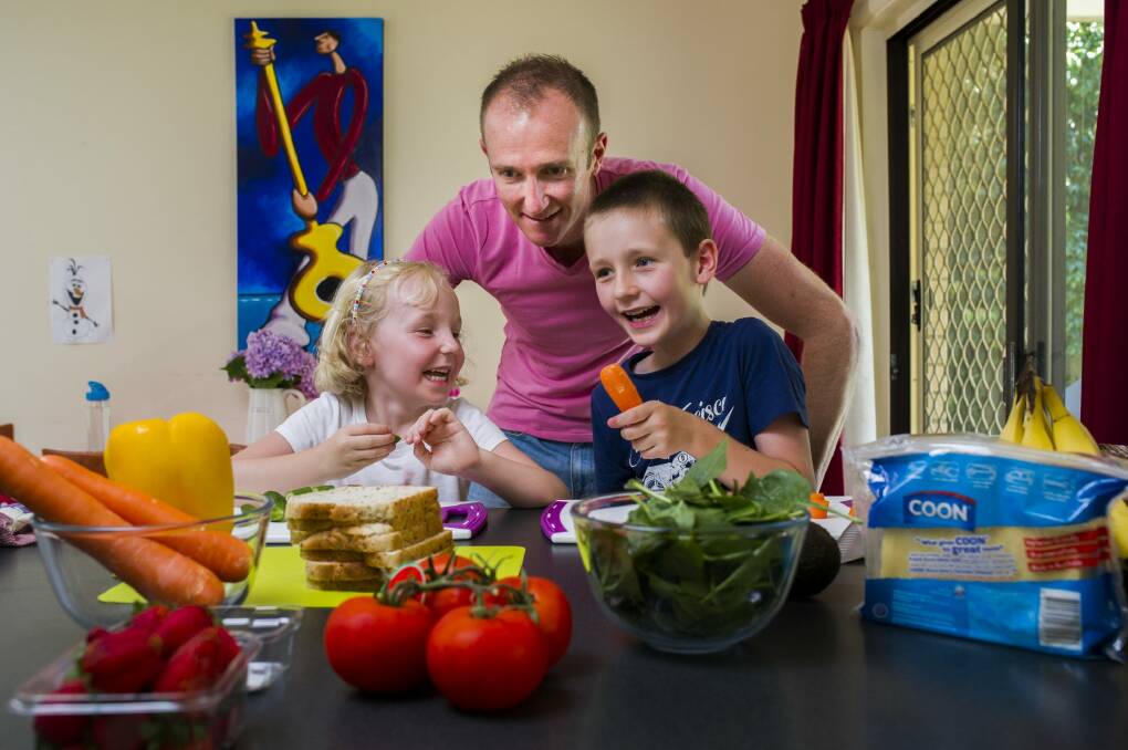 Neill Taylor with his children Imogen, 4, and Xavier, 7, making healthy sandwiches for lunch. Photo: Rohan Thomson