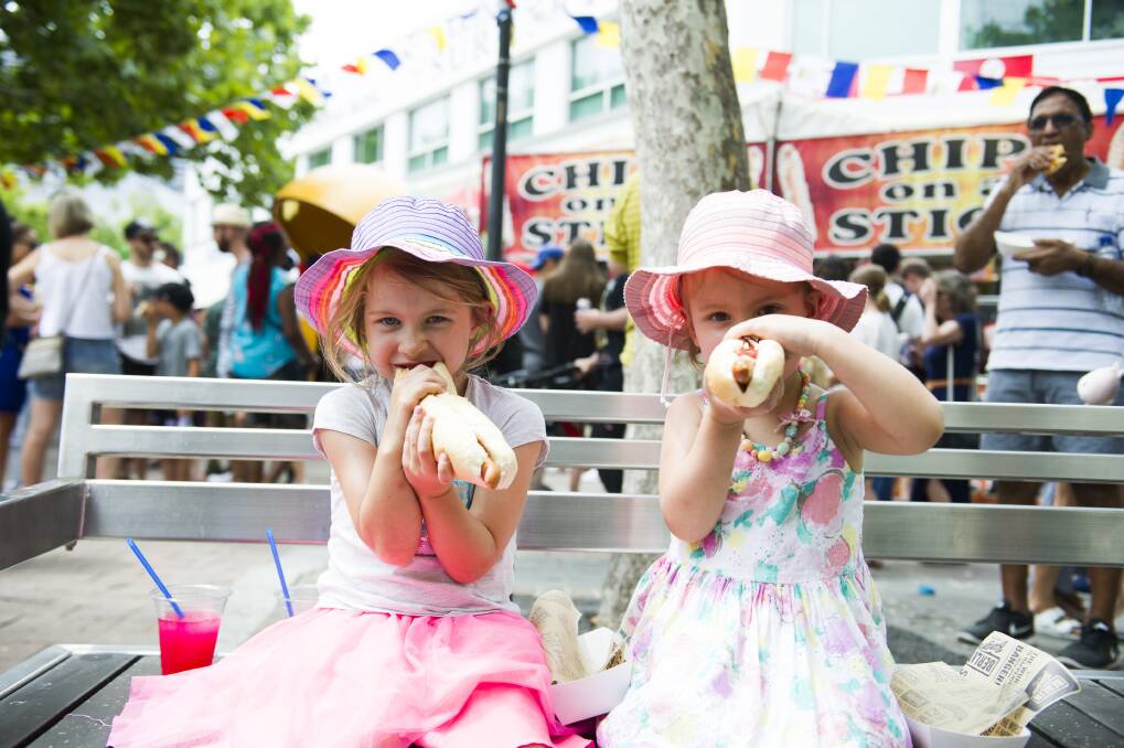 Olivia Shields, 6, and Isabelle Shields, 4, enjoy a German hotdog. Photo: Dion Georgopoulos