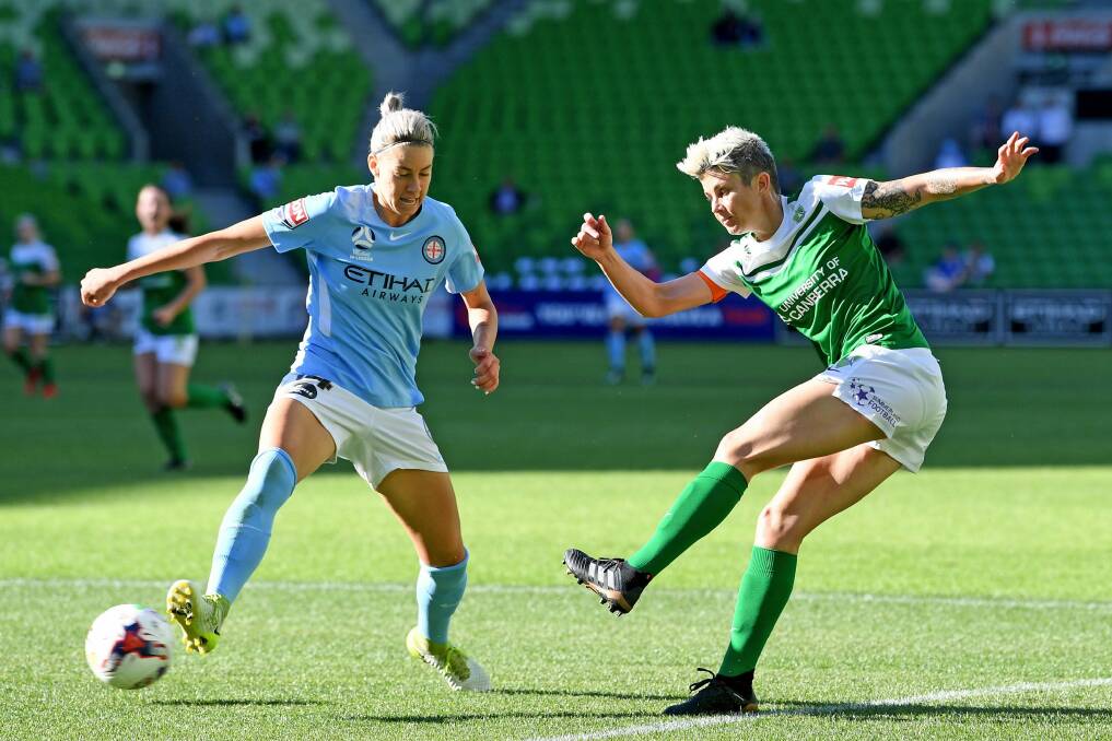 Michelle Heyman of United (right) strikes the ball past Alanna Kennedy of City during the round 7 W-League match between Melbourne City and Canberra United. Photo: AAP