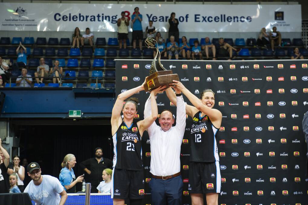 Kelsey Griffin, coach Paul Goriss and Marianna Tolo hold the grand final trophy. Photo: Dion Georgopoulos