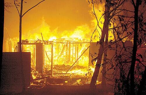 A house burns after being engulfed by a bushfire in the Canberra suburb of Duffy January 18, 2003. Photo: STRINGER/AUSTRALIA