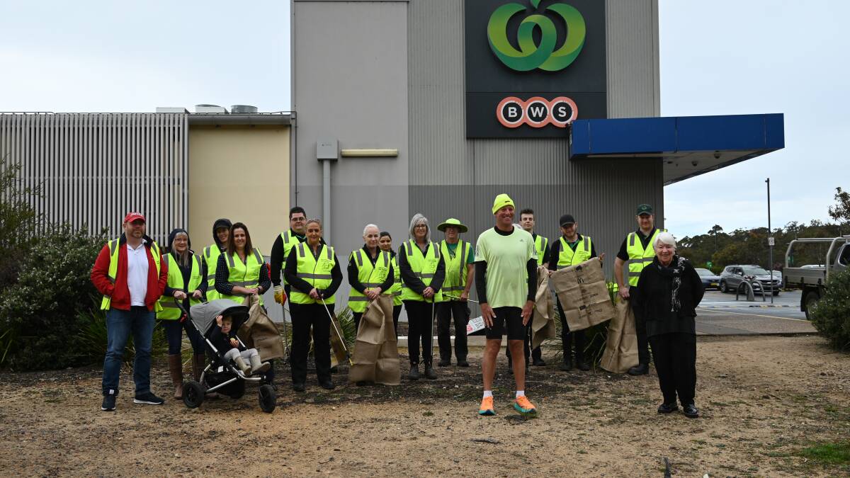 Dane and Junee Waites with the Woolworths crew at Tura Beach who have often helped Dane pick up rubbish. In November 2021 the crew picked up a ute load of rubbish in just 740 metres of bushland. Photo: supplied 