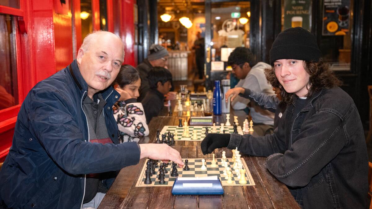 Miles Patterson and Jonah Gear take part in an attempt to set the world record for the most number of games of chess in a single day at King O'Malley's pub. Picture by Sitthixay Ditthavong
