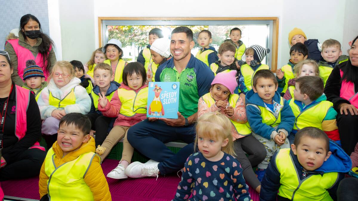 Canberra Raiders star Jamal Fogarty reads to children at Gungahlin library. Picture by Sitthixay Ditthavong