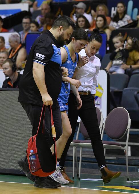 Jade Melbourne is helped off the court by coach Kristen Veal. Picture Getty Images