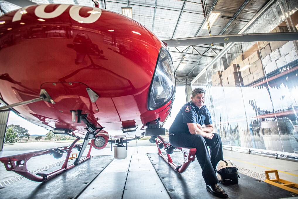 RFS ACT aviation officer Simon May sits at the skid of a 'squirrel' or Firebird 100, a lightweight helicopter, similar to the ones he managed during wildfires in Alberta, Canada. Picture by Karleen Minney