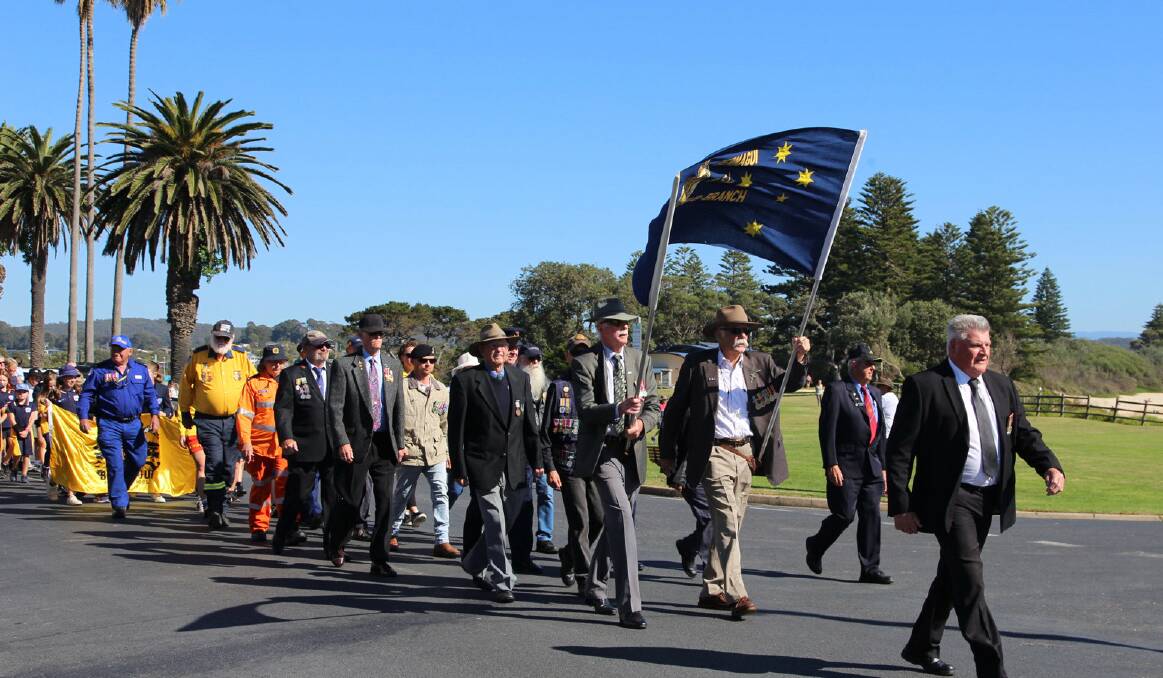 Parade president Neville Staehr led the march of veterans, Bermagui emergency services team and pupils from Bermagui Public School. Picture supplied.