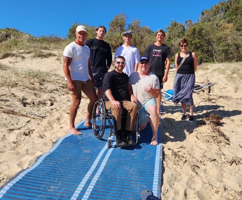 Lifeguards and volunteer lifesavers at Broulee learn how the new mobility mats roll out and peg into the sand, as well as how to pack them up ahead of storms or large seas. Photo supplied.