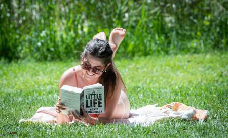 Bikini-clad Emily Bannister reads a book in the Sunshine on the ground of the ANU. Picture by Karleen Minney