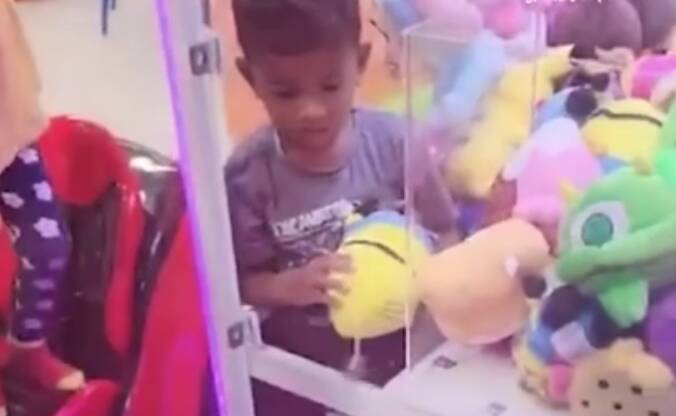 Determined toddler gets stuck in claw machine