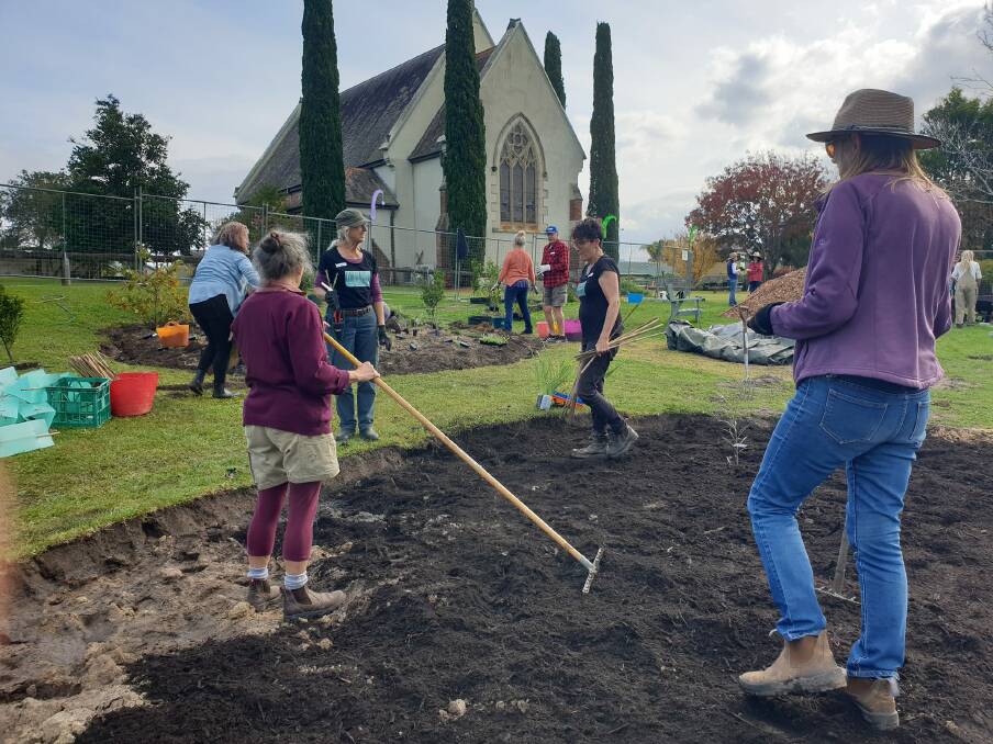 Volunteers spread nutrient-rich soil to establish the microforest's garden beds on May 13. Picture supplied