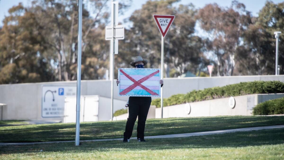 An anti-trans protester stands outside of Parliament House. Picture by Karleen Minney.