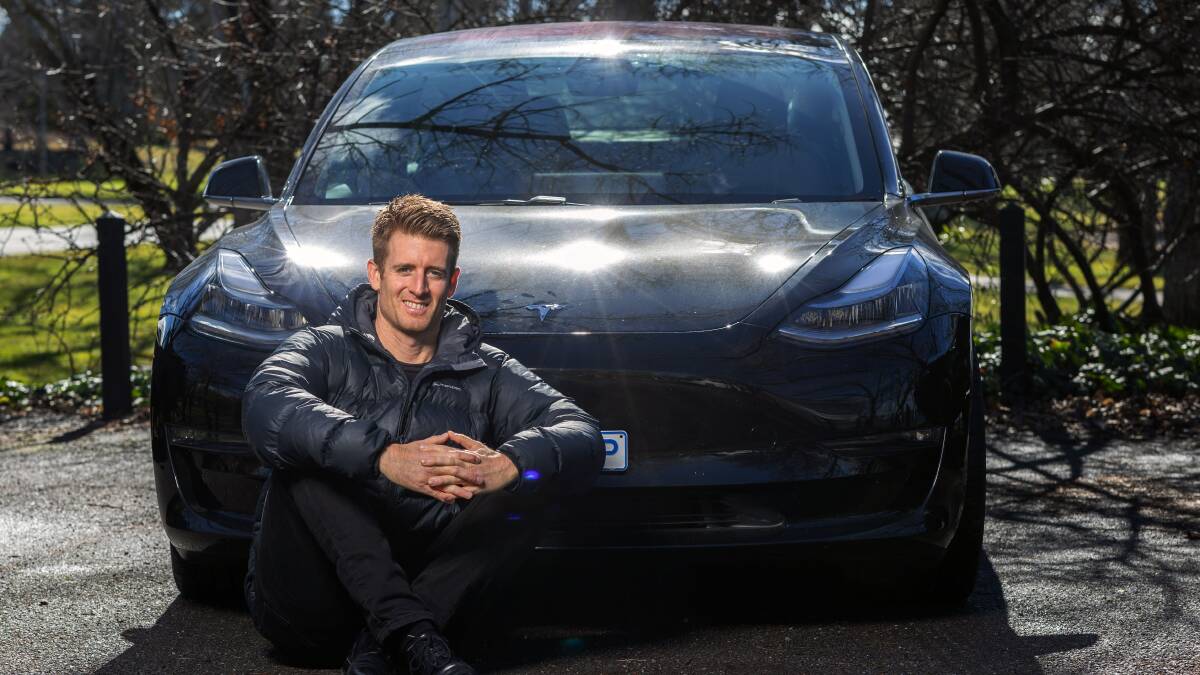Daniel Bleakley with his Tesla and a puffer jacket. Picture by Gary Ramage 