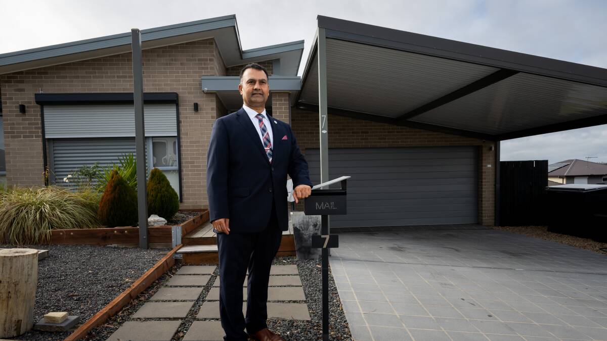 Real estate agent Shaun Iqbal in front of a home for sale in Bonner. Picture by Elesa Kurtz