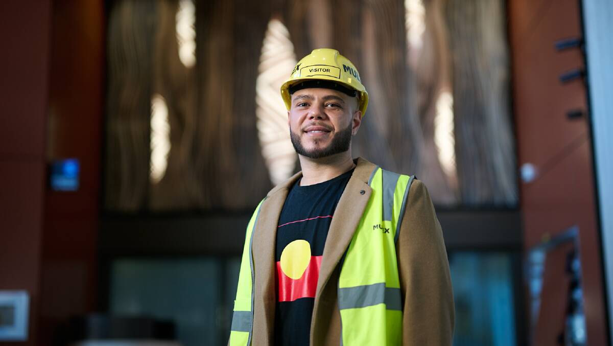 Ngunnawal artist Bradley Mapiva-Brown in front of his work. Picture by ACT government