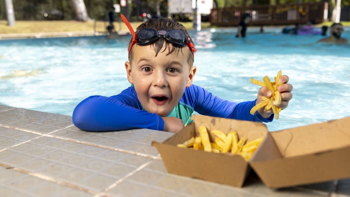 Judah Grening, 5, is happy hot chips are back at the Dickson Aquatic Centre. Picture by Gary Ramage