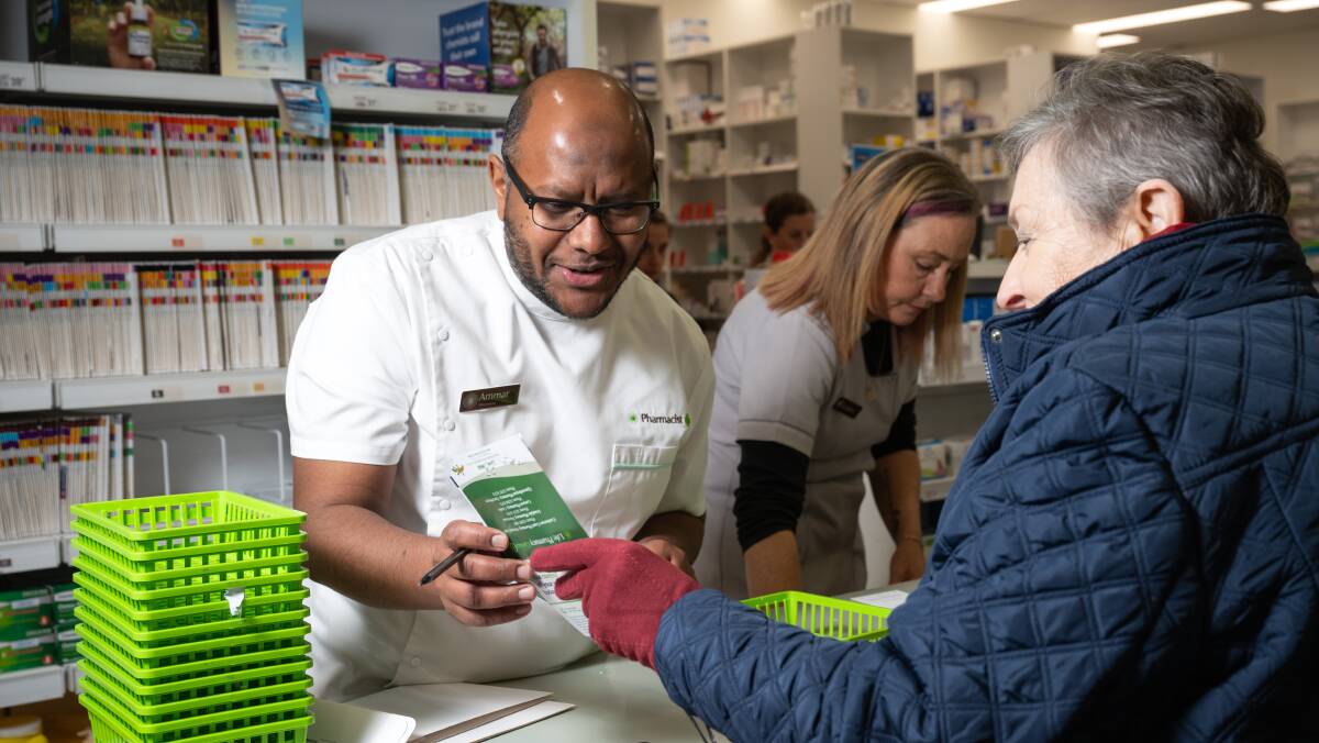 Ammar assisting customer Christine Rushall at the Queanbeyan Pharmacy. Picture by Elesa Kurtz
