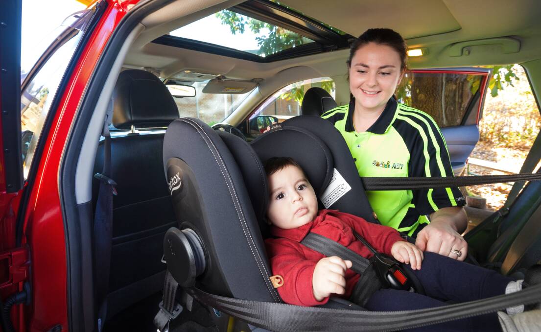 Kidsafe ACT staff member Natalie Hood checks the car seat of six-month-old Luciano at the Pearce centre. Picture by Sitthixay Ditthavong