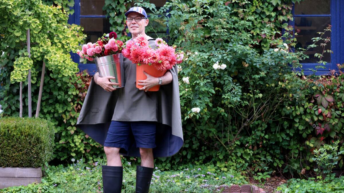 Have gumboots, will garden: Brian Tunks with some of the beautiful dahlias he will sell and help people to style at the Bison Glasshouse in Pialligo this weekend. Picture by James Croucher