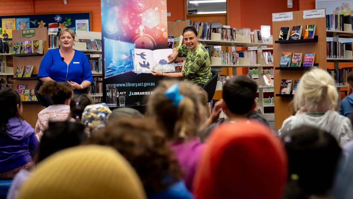 Canberra scientist Dr Kate Grarock (right), who appeared on Alone Australia, reads Bowerbird Blues to the kids at the Dickson library. With her is Libraries ACT executive branch manager Peta Harding. Pictures by Elesa Kurtz