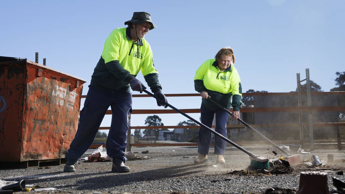 The Green Shed staff Julian Goodwin and Therese Evans cleaning up at the Mitchell shed on Wednesday. They will return to the same site next week as employees of the new contractor, Vinnies. Picture by Keegan Carroll