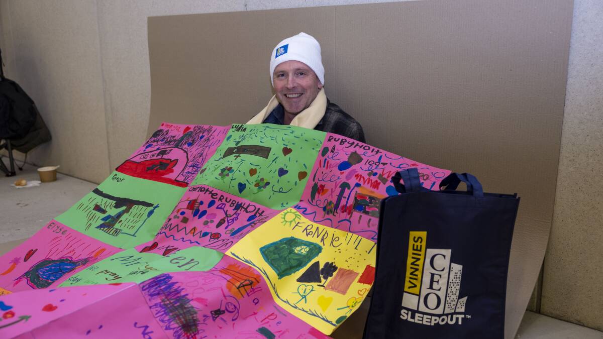 Michael Green, principal at Mount Carmel School in Yass, at the Vinnies CEO Sleepout in Canberra, with a quilt made for him by the kindergarten students. Picture by Gary Ramage