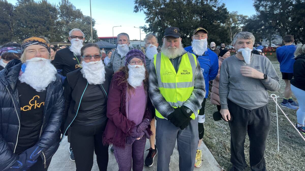 Neil Hewitt, centre, is celebrated by his hirsute mates as he chalked up 400 Parkruns and 100 volunteers at Tuggeranong on the weekend. Picture by Megan Doherty