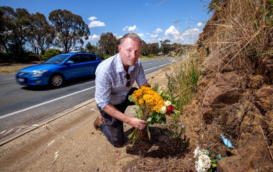Tom McLuckie places flowers where his son died on Hindmarsh Drive. Picture by Sitthixay Ditthavong