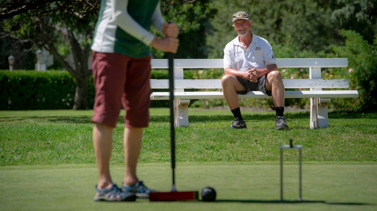 Canberra Croquet Club captain Peter Freer, right, watches a croquet game being played. Picture: Elesa Kurtz