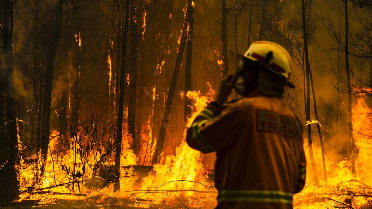 A bushfire on the south coast of NSW in 2019. A new report has found many government-owned corporations are not considering the risks of climate change to their businesses. Picture by Dion Georgopoulos