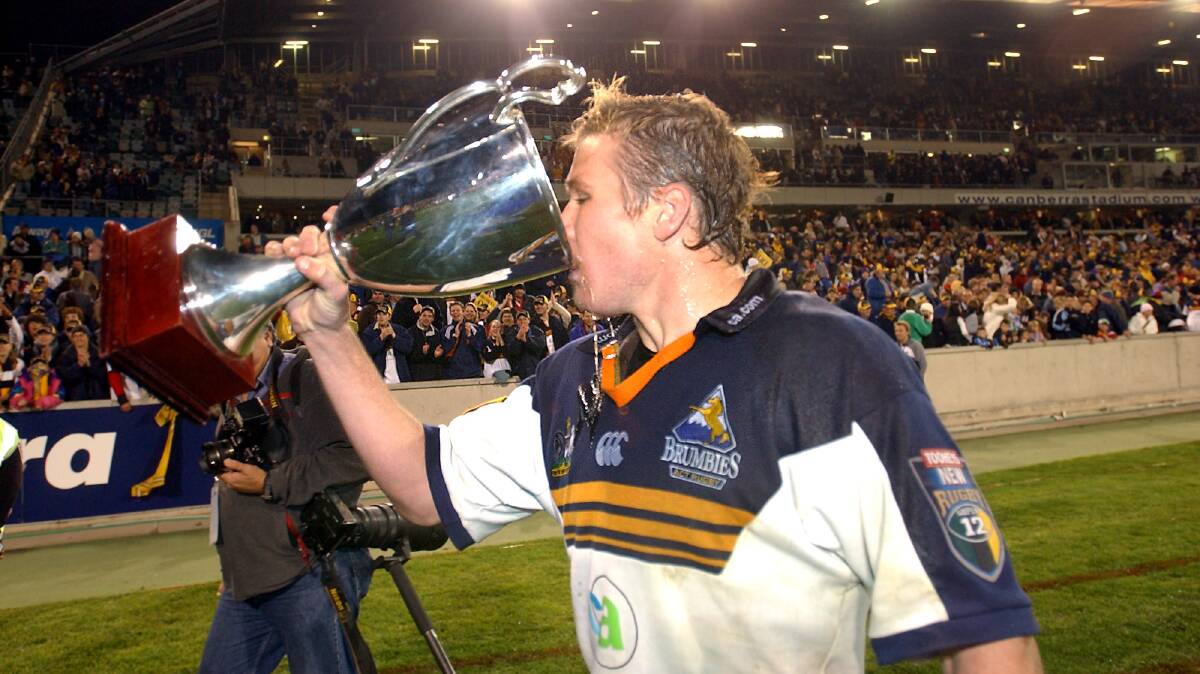 Matt Giteau drinking from the Super Rugby trophy. Picture by Jodie Richter