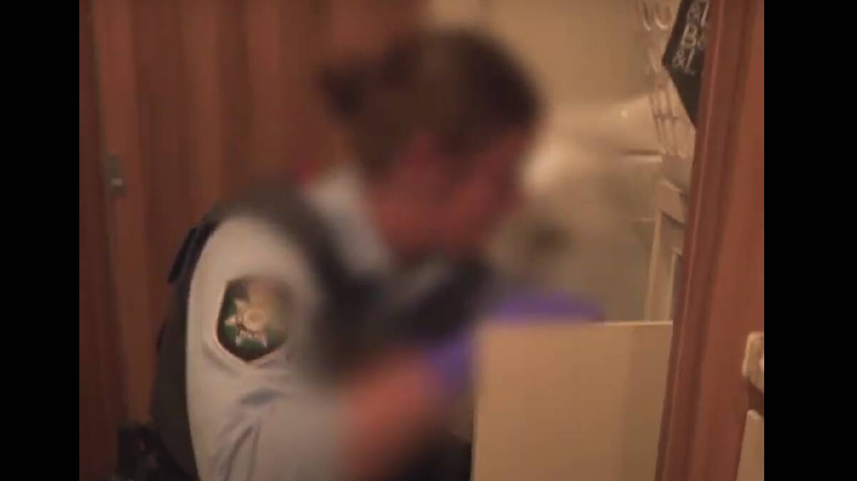 A police officer searches a property during raids conducted as part of Operation Goeben.
