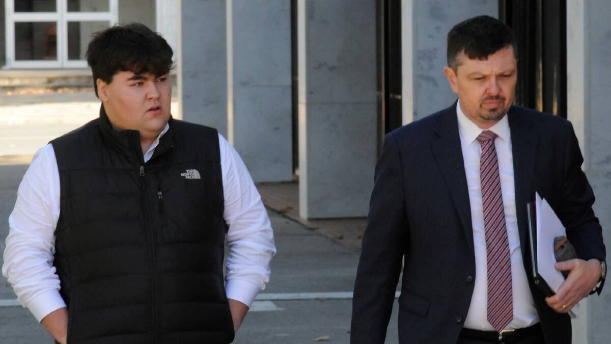 Angus Gottaas-Hughes, left, takes some of his final steps of freedom with solicitor Michael Kukulies-Smith. Picture by Blake Foden