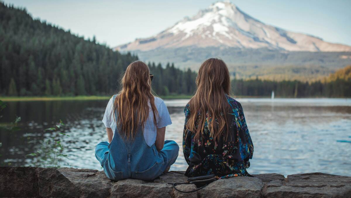 Two women sitting alongside each other. Picture is by Roberto Nickson, Unsplash