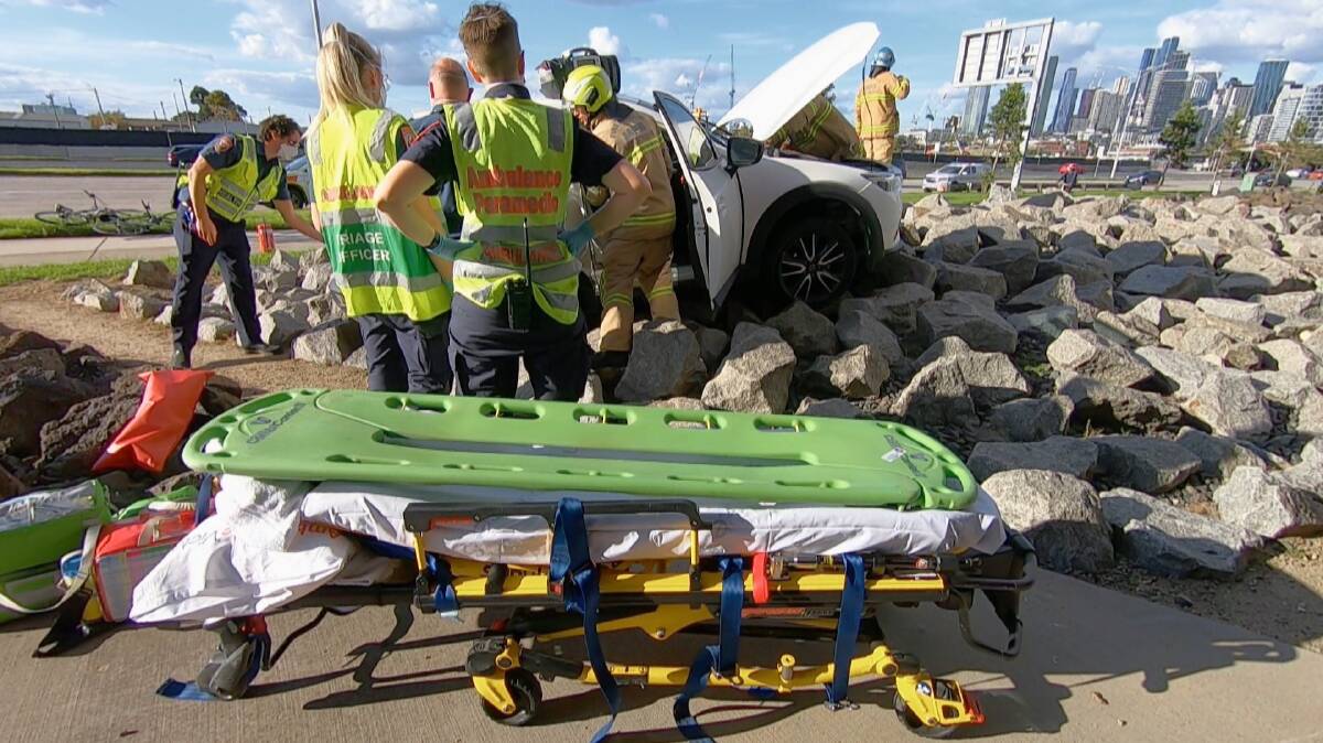 Paramedics at work helping a female driver after she suffered a medical episode while behind the wheel