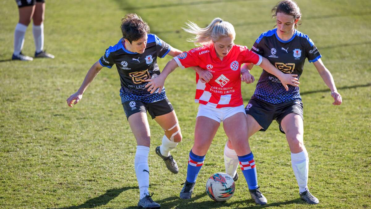 Canberra Croatia's Bella Barac shields the ball against Canberra Olympic's Sarah Johnston and Victoria Jamieston. Picture: Sitthixay Ditthavong