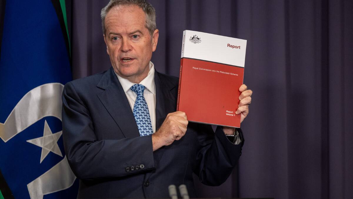 Bill Shorten with the robodebt royal commission report. It is not the job of public servants to make government policy. Picture by Gary Ramage