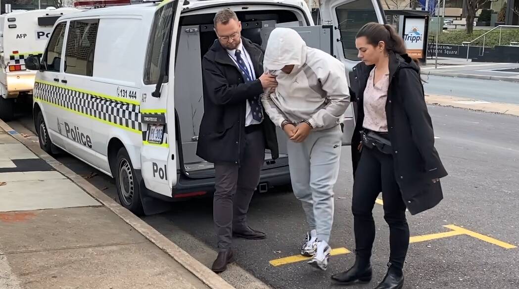 Police escort the 18-year-old man into City Police Station in a second arrest over alleged home invasion. Picture supplied