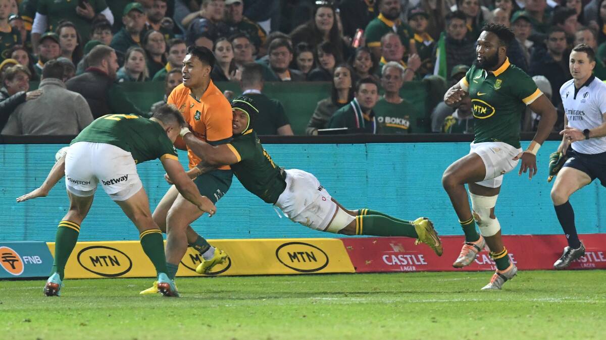 Wallabies centre Len Ikitau is tackled by the Springboks defence. Picture Getty Images